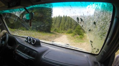 Araba penceresinden dağlara ve ormana bak. Offroa