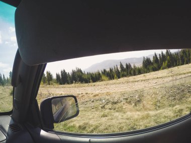 Araba penceresinden dağlara ve ormana bak. Offroa