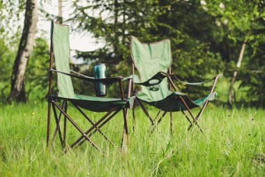 Katlanır sandalyeler ve bir masa ile dağlarda Piknik. Araba