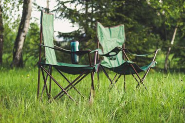 Katlanır sandalyeler ve bir masa ile dağlarda Piknik. Araba