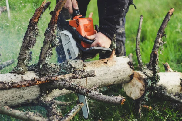 El tipo corta el viejo árbol en las montañas con una motosierra. Ukr — Foto de Stock