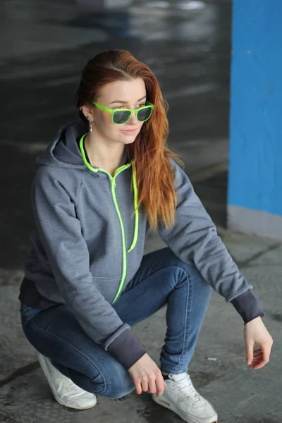 Menina com cabelo vermelho com capuz cinza. Estilo de rua. Sutiã publicidade — Fotografia de Stock