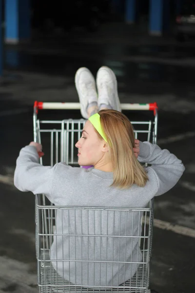 Chica es una entrenadora rubia en una delgada gris. Estilo callejero. Advertisi — Foto de Stock