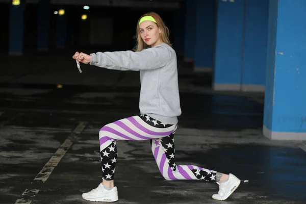 Girl is a blonde trainer in a gray thin. Street style. Advertisi — Stock Photo, Image