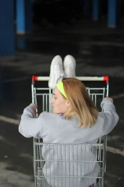 Chica es una entrenadora rubia en una delgada gris. Estilo callejero. Advertisi — Foto de Stock