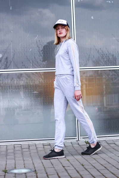 Het meisje is blond in een grijze Sportpak. Straat kleding. Sport — Stockfoto