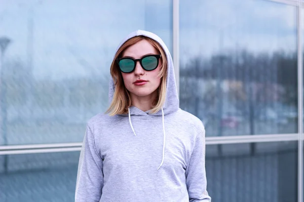 La chica es rubia con un traje deportivo gris. Ropa de calle. Deporte —  Fotos de Stock