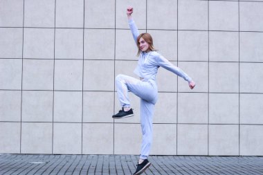 Kız gri spor takım elbiseli sarışın. Sokak kıyafetleri. Spor