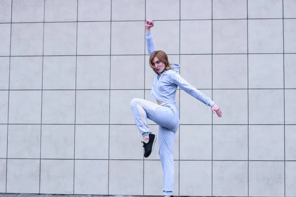 La ragazza è bionda con un completo sportivo grigio. Abbigliamento stradale. Sport — Foto Stock