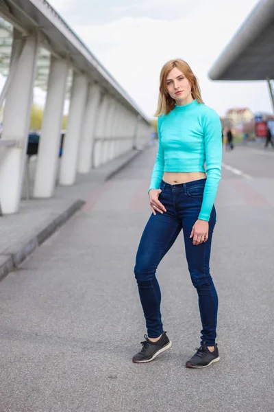 A menina é loira em um croptop azul. Roupa de rua. Desporto. Anúncio — Fotografia de Stock