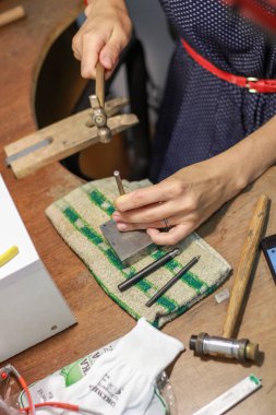 Bir mücevher ustası gümüş bir yüzük oluşturmak için çalışıyor