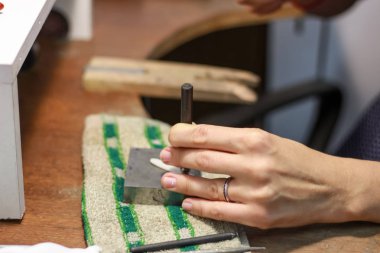 Bir mücevher ustası gümüş bir yüzük oluşturmak için çalışıyor