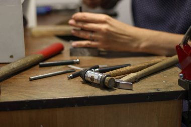 Bir mücevher ustası gümüş bir yüzük oluşturmak için çalışıyor