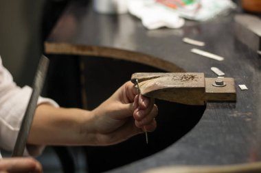 Bir mücevher ustası gümüş bir yüzük oluşturmak için çalışıyor