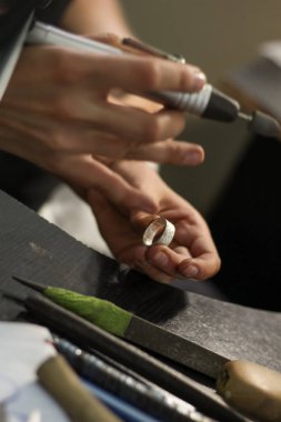 Bir mücevher ustası gümüş bir yüzük oluşturmak için çalışıyor