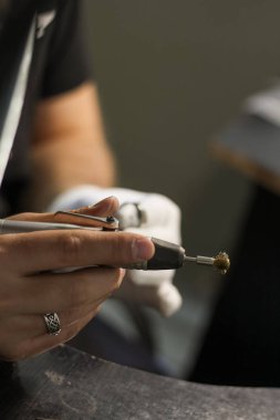 Bir mücevher ustası gümüş bir yüzük oluşturmak için çalışıyor