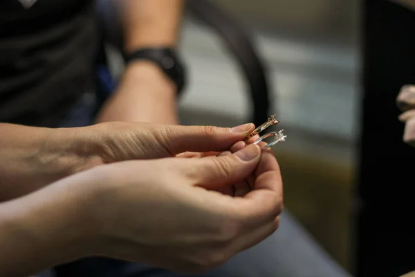 A jewelry master is working to create a silver ring