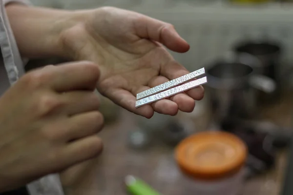 A jewelry master is working to create a silver ring