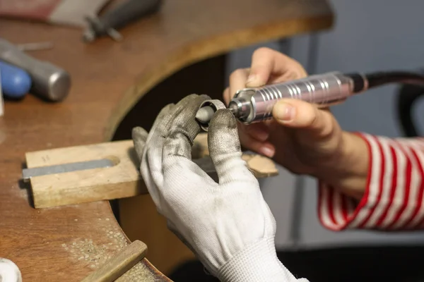 A jewelry master is working to create a silver ring