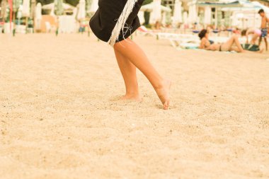 Kumda kadın bacakları. İnsan ayağı. Deniz. Reklam