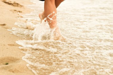 Kumda kadın bacakları. İnsan ayağı. Deniz. Reklam
