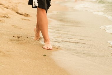 Kumda kadın bacakları. İnsan ayağı. Deniz. Reklam
