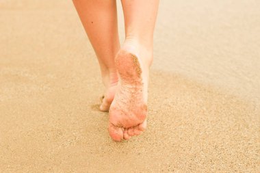 Kumda kadın bacakları. İnsan ayağı. Deniz. Reklam