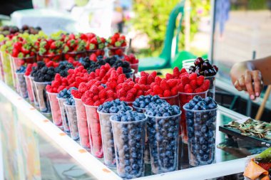 Pazarda çilek. Sokakta meyve tepsisi var. Sokak yemekleri. Ras