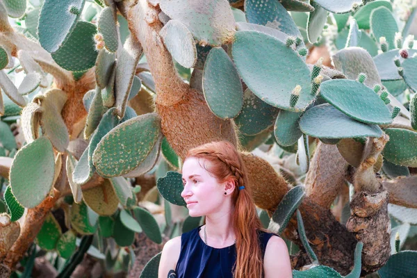 Chica joven pelirroja. Retrato. Diviértete. Cactus en el backgrou — Foto de Stock