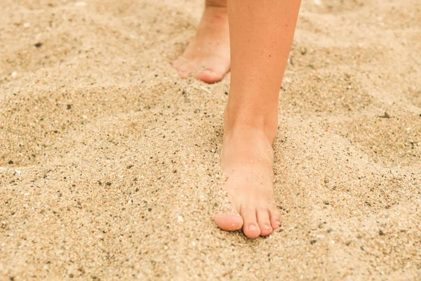 Kvinnliga ben i sanden. Mänsklig fot. Havet. Reklam — Stockfoto