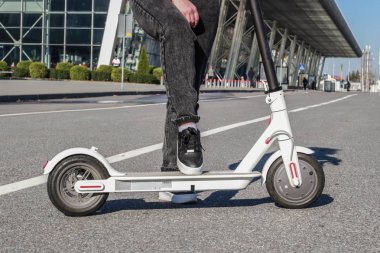Ayaklar elektrikli scooter 'da. Geleceğin ulaşımı. Spor ayakkabılar