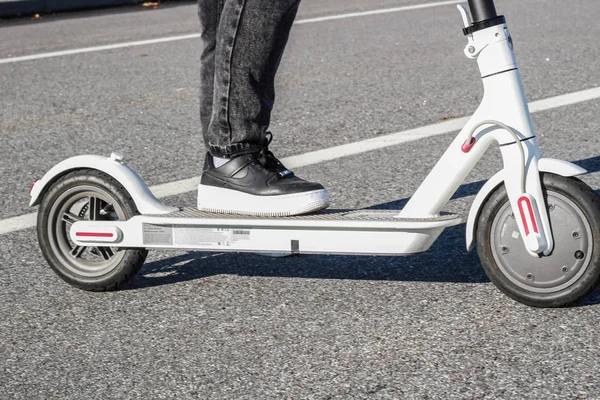 Pies en scooter eléctrico. Transporte del futuro. Zapatillas deportivas — Foto de Stock