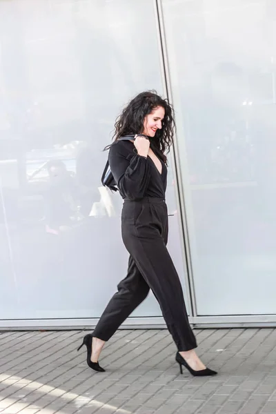 Chica de pelo negro. Mujer de negocios con estilo. Un mono negro. Traje. — Foto de Stock