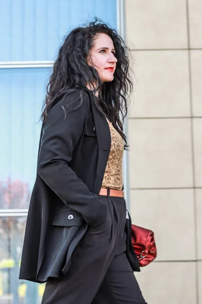 Черноволосая девушка. Стильная деловая женщина. Черный костюм и красный ха — стоковое фото