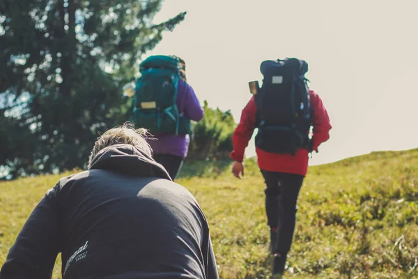 Dağlarda kız ve erkek yürüyüşçüler. Seyahat çantaları ve giysileri. — Stok fotoğraf