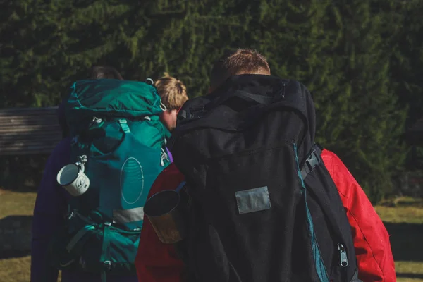 Dağlarda kız ve erkek yürüyüşçüler. Seyahat çantaları ve giysileri. — Stok fotoğraf