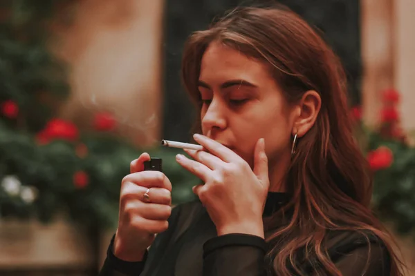 Una chica elegante fuma un cigarrillo. Fuma. Esmog. Negro elegante golf — Foto de Stock