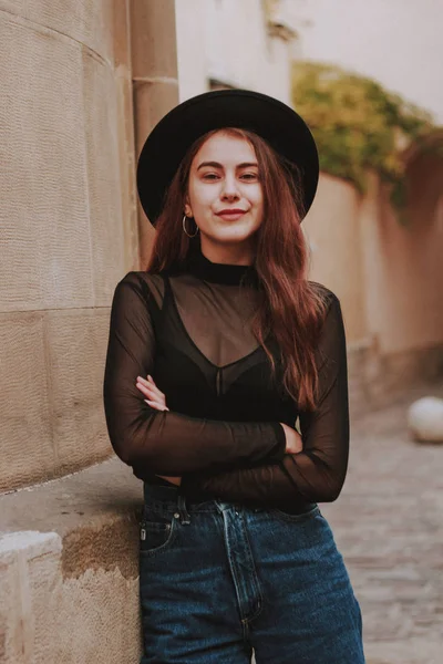 Menina elegante em um chapéu preto. Flores. Preto elegante Golf e Jea — Fotografia de Stock