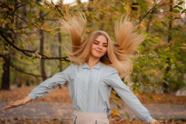 Sonbahar kızı portreleri. Pastel mavi gömlekli bir model. Uçan saç. 