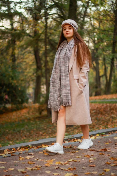 Herfst meisje portretten. Beige jas, hoed, witte sneakers. Succesf — Stockfoto