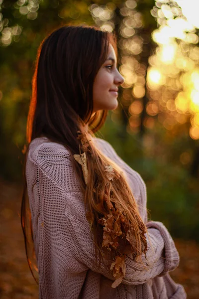 Herbstliche Mädchenporträts. Sonnenuntergang. rosafarbener Strickpullover. gelbes Blatt — Stockfoto