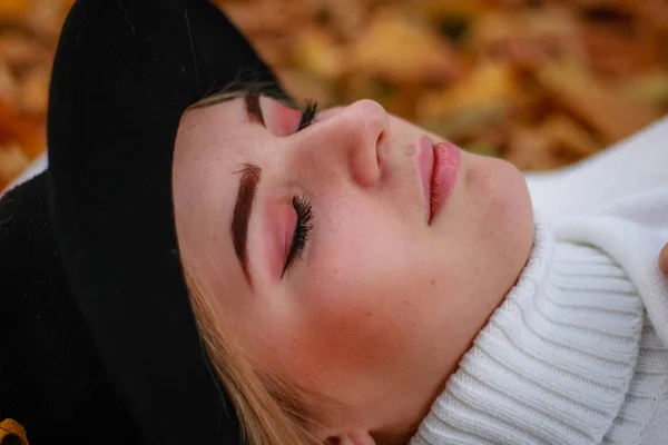 Podzimní dívčí portréty. Model v bílém svetru leží na žlutém lea — Stock fotografie