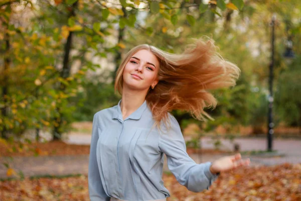 Herfst meisje portretten. Model in pastelblauw shirt. Vliegend haar. — Stockfoto