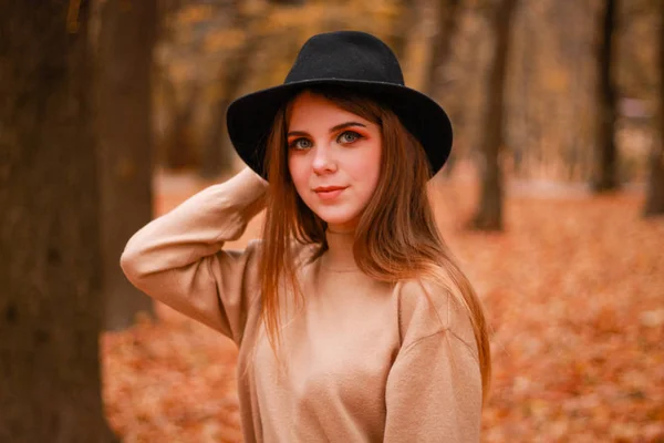 Herfst meisje in het park. Trui, hoed en leren rok. Stijlvol — Stockfoto