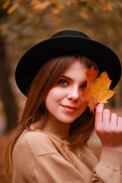 Herfst meisje in het park. Trui, hoed en leren rok. Stijlvol — Stockfoto