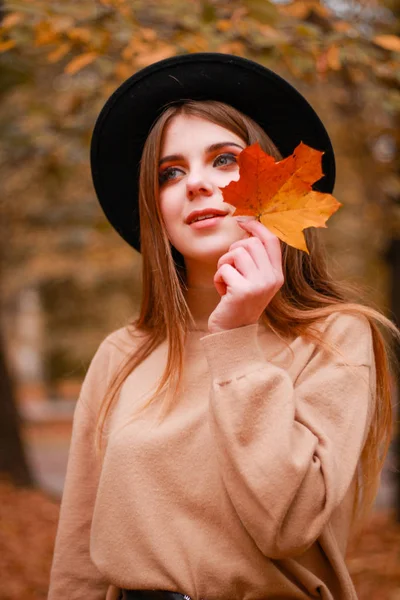 Herfst meisje in het park. Trui, hoed en leren rok. Stijlvol — Stockfoto
