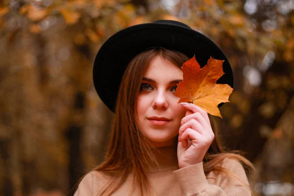 Höstflickan i parken. Tröja, hatt och läderkjol. Snygg — Stockfoto