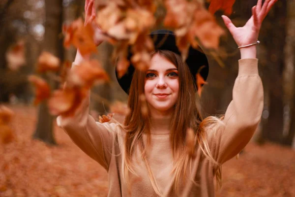 Herfst meisje in het park. Trui, hoed en leren rok. Stijlvol — Stockfoto