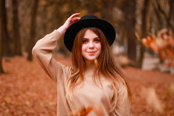 Herfst meisje in het park. Trui, hoed en leren rok. Stijlvol — Stockfoto