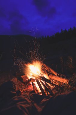 Turistler dağlara bakan ateşin tadını çıkarıyorlar. Sonbaharda sıcak bir atmosfer. Ukrayna Karpat Dağları